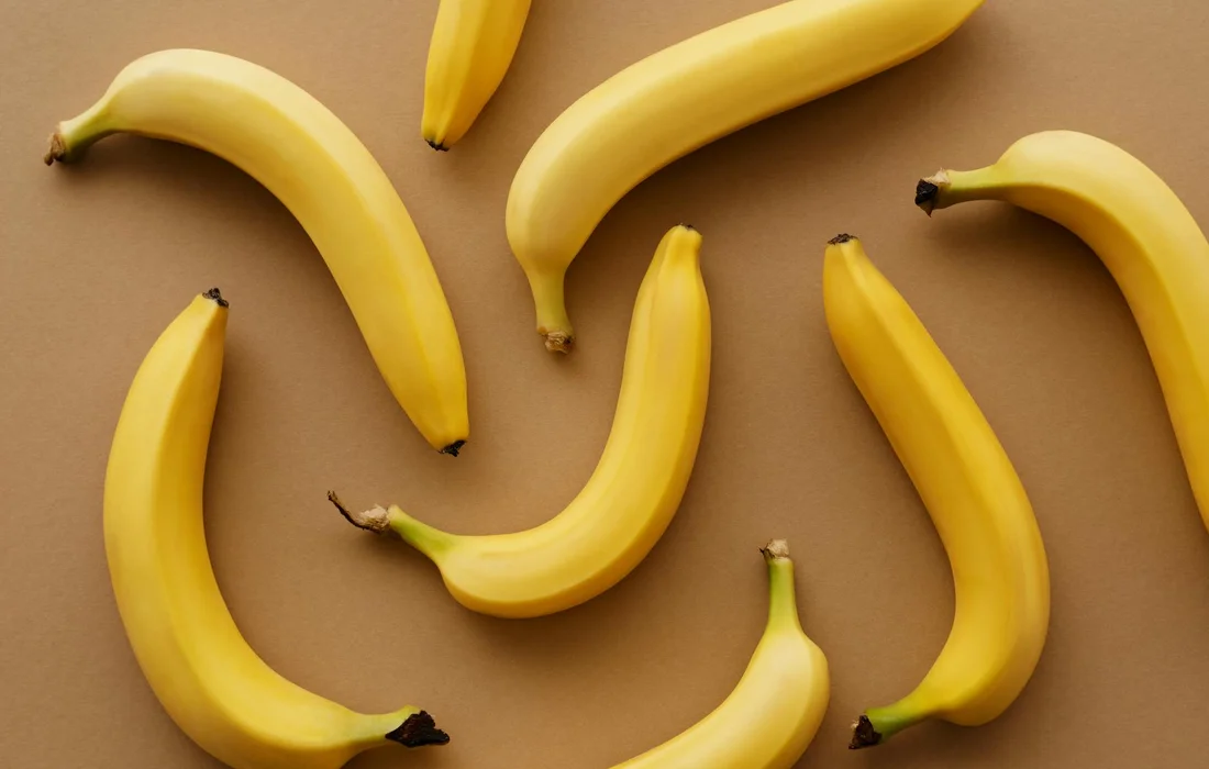 Several yellow bananas arranged on a brown background