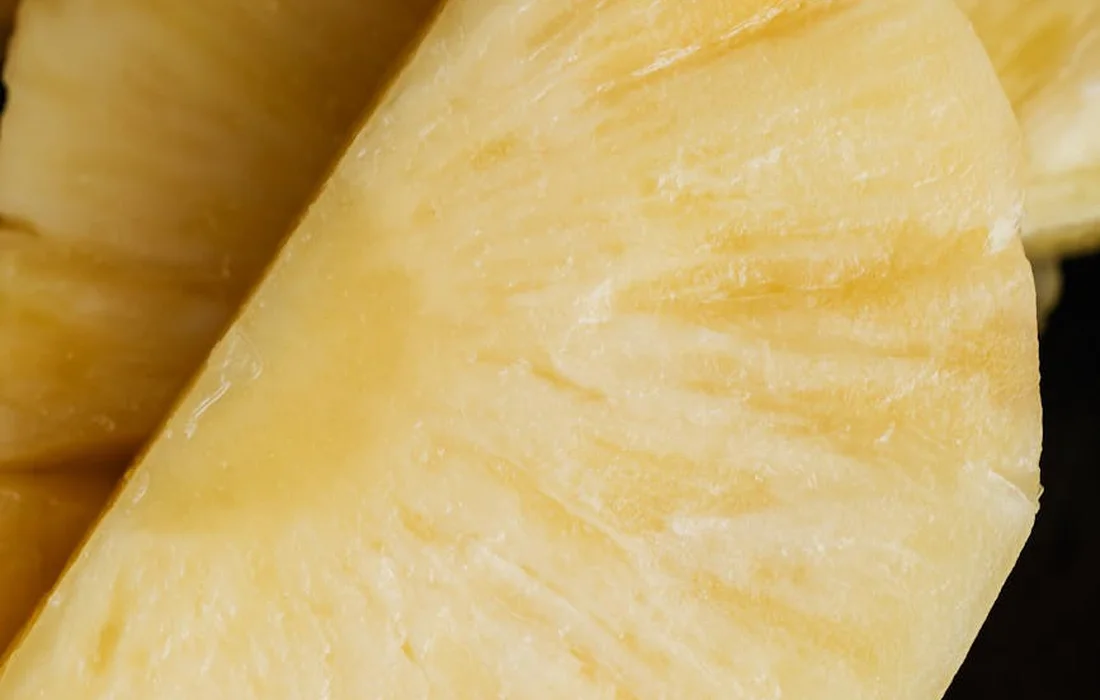 Close-up view of a pineapple slice showing its yellow flesh and textured surface