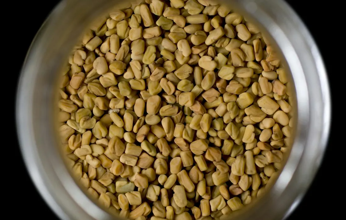 Top-down view of a metal bowl filled with pine nuts