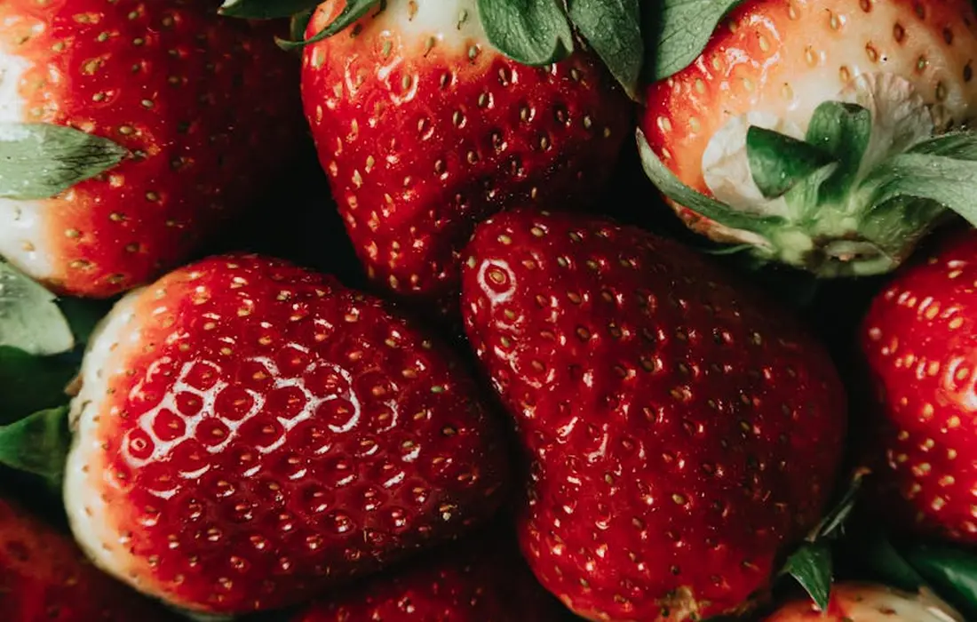 Close-up of ripe strawberries with green leaves