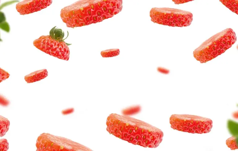 Floating strawberry slices scattered on a white background
