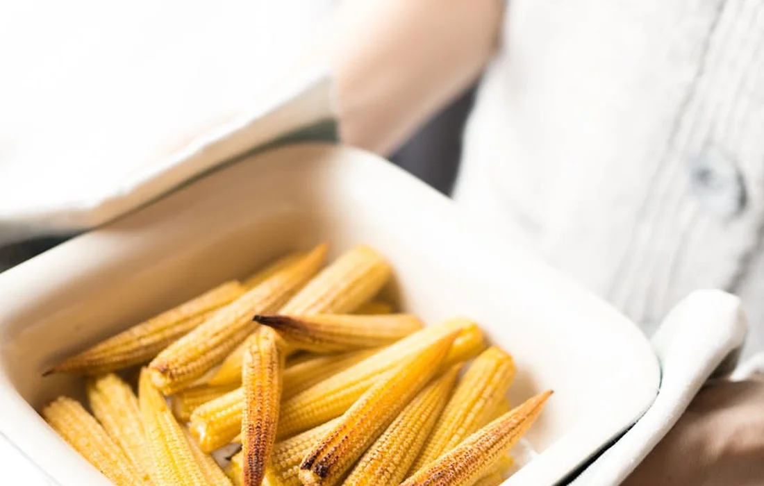 Small pieces of corn in a white dish, illustrating an example of a snack rabbits should avoid.